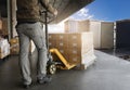 Warehouse Worker Unloading Shipment Boxes into Cargo Container Truck. Cargo Trailer Truck Parked Loading at Dock Warehouse.