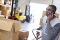 Warehouse worker using mobile phone Royalty Free Stock Photo