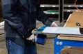 Warehouse worker using a shrink wrap handheld dispenser to fulfill an order.