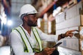 Warehouse worker working process checking the package with a tablet in a large distribution center