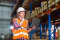 Warehouse worker working process checking the package using laptop in large warehouse distribution center. Caucasian female Royalty Free Stock Photo