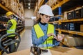 Warehouse workers checking stuff in warehouse with digital system in tablet, holding solar panel. Royalty Free Stock Photo