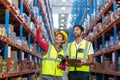 Warehouse workers discussing with clipboard while working Royalty Free Stock Photo