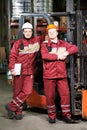 Warehouse workers in front of forklift Royalty Free Stock Photo