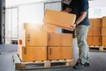 Warehouse Workers Lifting Package Boxes Stack on Pallet. Shipment Boxes, Supplies Warehouse Shipping. Royalty Free Stock Photo