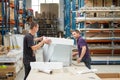 Warehouse workers pack equipment before shipment to customer