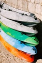 A warehouse of yellow, blue, green, grey kayaks on shore. Single kayaks. Rental kayakshop store on sandy beach Royalty Free Stock Photo