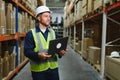 Warehouseman checking delivery, stock in warehouse on laptop. Warehouse manager using warehouse management software, app Royalty Free Stock Photo