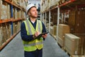 Warehouseman checking delivery, stock in warehouse on laptop. Warehouse manager using warehouse management software, app Royalty Free Stock Photo