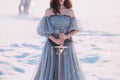 Warlike girl with dark hair in long gray vintage light dress, lady of cold and frost, bare open shoulders and sharp