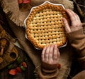 Warm baked apple lattice pie crust in woman hands on sackcloth Royalty Free Stock Photo