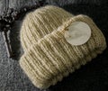 Warm handmade beige winter hat for women with an emty tag on it