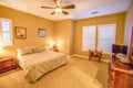 Warm bedroom with ceiling fan and shutters Royalty Free Stock Photo