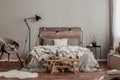 Warm bedroom interior with king size bed with wooden headboard with light, fury blanket