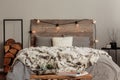 Warm fury blanket on grey duvet on king size bed in stylish rustic bedroom interior