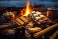 warm campfire with smores ingredients on nearby log