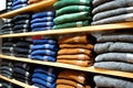 Warm clothing neatly folded on a shelf. A row of colorful jumpers, cardigans, sweatshirts, sweaters, hoodies in the Royalty Free Stock Photo