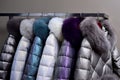 Warm coats with fur collars hanging on rack Royalty Free Stock Photo