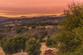 Warm color sunset sky, orange, red, lavender tones, in southern California hills in autumn, oaks in foreground mountains in backgr