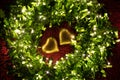 A warm color light garland surrounding two hearts. valentine`s day