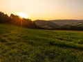 Warm colored bright golden epic sunrise rural panoramic landscape image with a wide view over fields,forest,hills and valleys Royalty Free Stock Photo