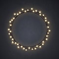 Warm colored Christmas incandescent light string wreath on the dark grey background. outdoor patio lights.