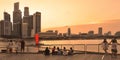 Warm colorful sunset on modern buildings and architectures in Marina Bay Sands with people relaxing on docks and watching skyline Royalty Free Stock Photo