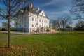 Naked trees, fallen autumn leaves and white palace