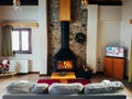 Warm cosy fireplace in mountain chalet with real firewood burning. Cozy winter concept. Winter vacation.