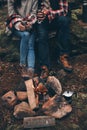 Warm and cozy. Close up of young couple holding cups while warming up near the campfire