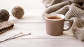 Warm and cozy: a cup of tea surrounded by knitted items and wool yarn balls Royalty Free Stock Photo