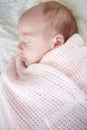 Warm and cozy in her blankie. A beautiful infant girl sleeping while wrapped up in a blanket.