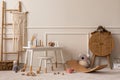 Warm and cozy kids room interior with white desk, stool, rattan sideboard, stylish toys, plush monkey, koala, macrame, wooden