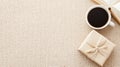 A warm cup of coffee sits beside a wrapped gift and an open book on a textured fabric surface, creating a serene Royalty Free Stock Photo