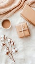 A warm cup of coffee sits beside a wrapped gift and an open book on a textured fabric surface, creating a serene Royalty Free Stock Photo
