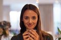 A warm cup of tea picks me right up. Portrait of a young woman drinking a warm beverage at home.