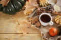 Warm cup of tea, pumpkins, fall leaves, cozy scarf on rustic wooden table with space for text. Hygge autumn banner. Happy Royalty Free Stock Photo