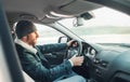 Warm dressed Bearded Man driving a new modern auto. Inside car view