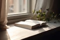 Ai Generative Open book on the windowsill in the morning sunlight. Selective focus