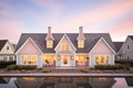 warm evening light washing over a cape cod and its symmetrical dormers