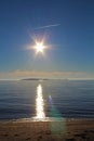 The sun setting over the beach near Port Hood in Nova Scotia with an island and an airplane on a summer day