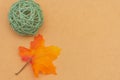 Warm fall seasonal orange  flatlay with festive green wicker reed ball and maple leaf on open concept and copy space availability Royalty Free Stock Photo