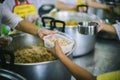 Warm food scooped from ladle into a container of the poor: the concept of giving