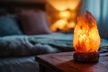 Warm glow of Himalayan salt lamp on wooden bedside table, soft focus on cozy bedroom background, perfect for wellness