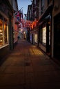 Warm glow of shop lights on Sandgate at night. Whitby, North Yorkshire.