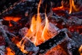 A warm, glowing campfire with orange flames and logs crackling in the heat Royalty Free Stock Photo