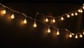 Warm glowing string lights on dark background bulbs Royalty Free Stock Photo