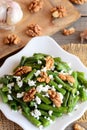 Warm green beans salad. Simple green beans salad with cottage cheese, raw walnuts, garlic and spices on a plate