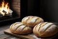 Next to a cozy fireplace, you\'ll find a trio of freshly baked loaves of bread resting on a wooden cutting board.