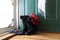 Warm and welcoming image of ladies Winter boots, gloves, scarf and hat near open door of home Royalty Free Stock Photo